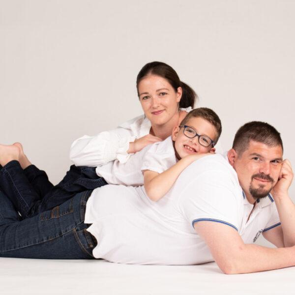 Séance photo famille les parents et le jeune fils les uns sur les autres -photographe de famille- krystyne ramon - home studio photos