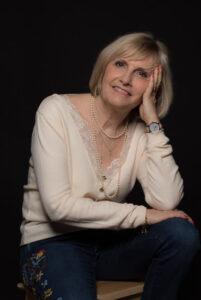 portrait d'une femme sur un tabouret un bras posé sur le genou et la tête posée sur sur main photographe de portrait- krystyne ramon - home studio photos