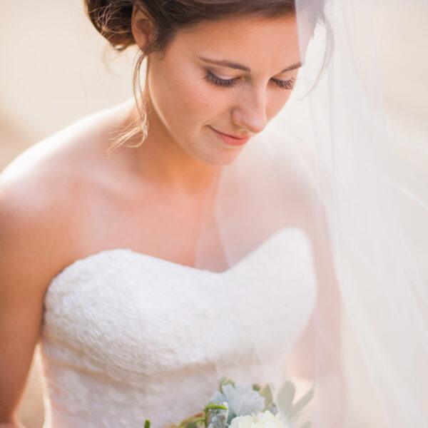 la mariée sous son voile son bouquet a la main -photographe de mariage