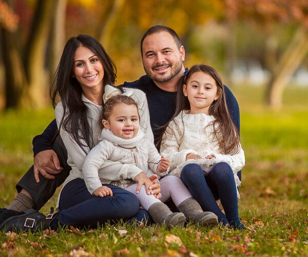 Séance famille dans les bois les parents assis ainsi que leurs 2 petites filles -photographe de famille