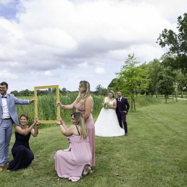 couple de mariés dans un cadre doré tenu par les témoins- photographe de mariage- krystyne ramon