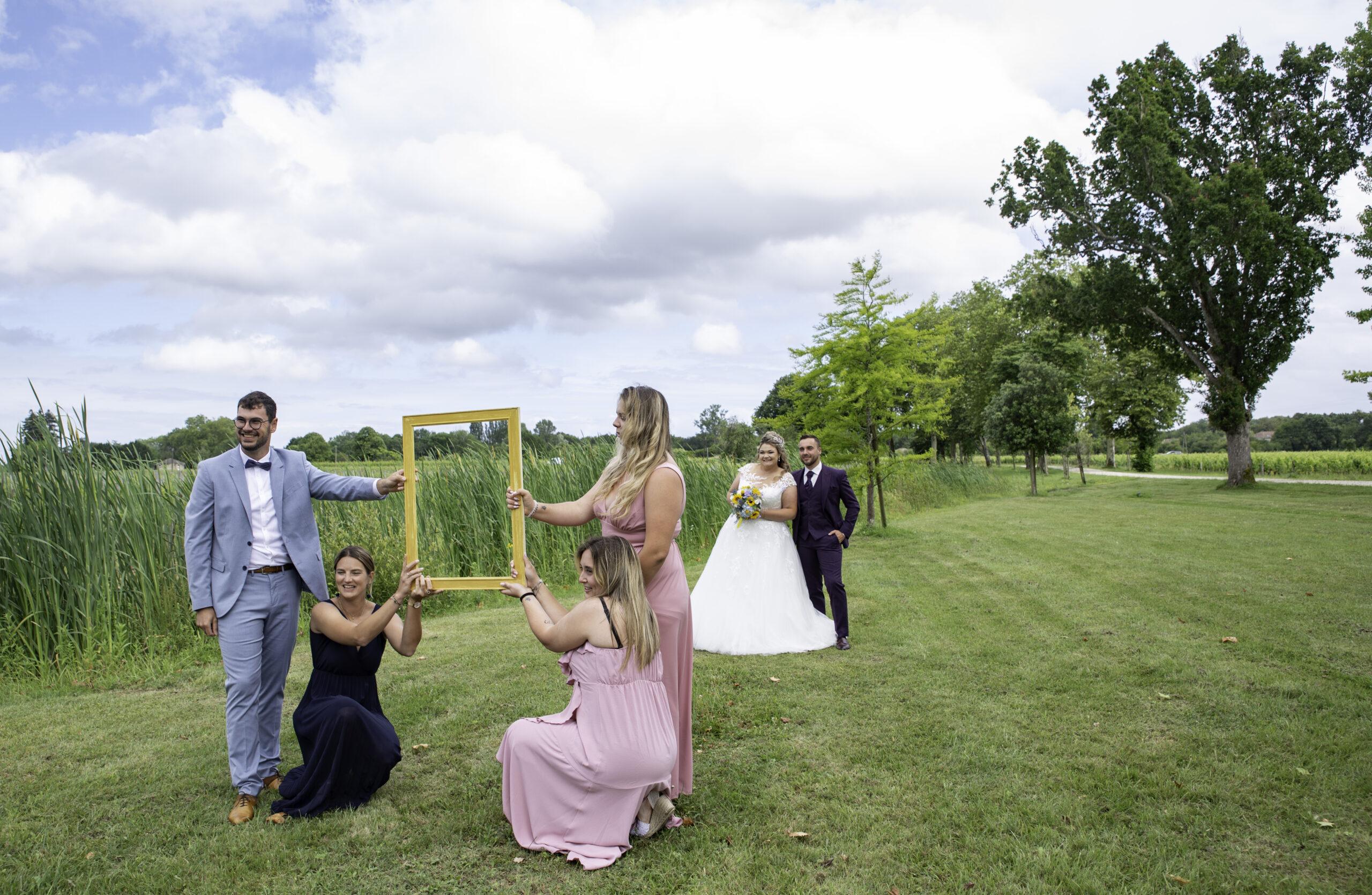 couple de mariés dans un cadre doré tenu par les témoins