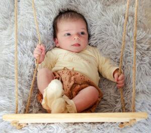nouveau-né posé sur une fausse balançoire -photographe de naissance- krystyne ramon