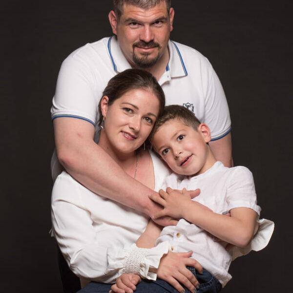 Parents enlacés avec leur fils dans les bras de sa maman -photographe de famille- krystyne ramon - home studio photos