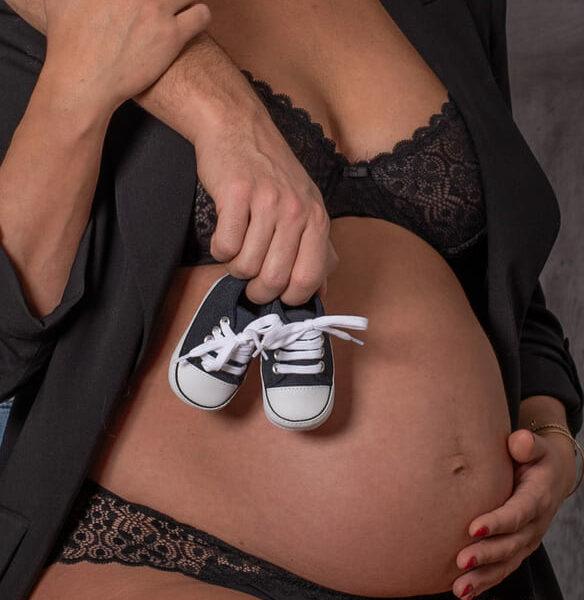 Petite paire de chaussure bebe sur le ventre de la future maman -photographe de grossesse- krystyne ramon