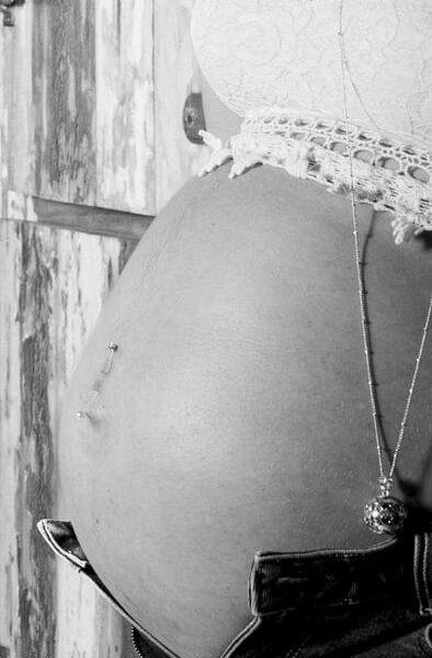 photo de grossesse future maman appuyée sur une porte en bois -photographe de grossesse- krystyne ramon