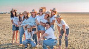 séance EVJF groupe de neufs jeunes filles sur la plage qui portent la future mariée