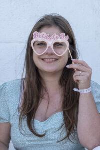 séance EVJF la future mariée sourit avec sur les yeux des fausses lunettes bride to be