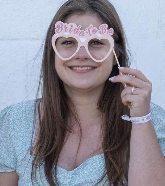 séance EVJF la future mariée sourit avec sur les yeux des fausses lunettes bride to be krystyne ramon - home studio photos