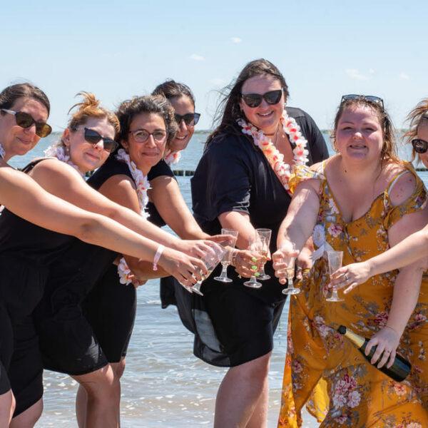 séance EVJF groupe de sept jeunes filles en arc de cercle le bras tendu avec une coupe de champagne a la main krystyne ramon - home studio photos