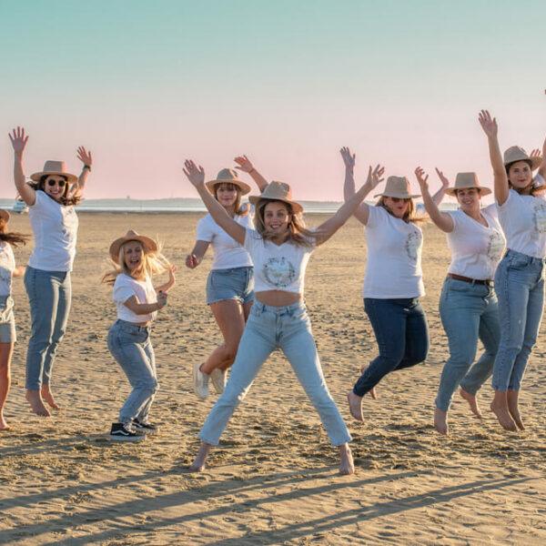 séance photo EVJF dix jeunes filles sur la plage sautent les bras en l'air krystyne ramon - home studio photos
