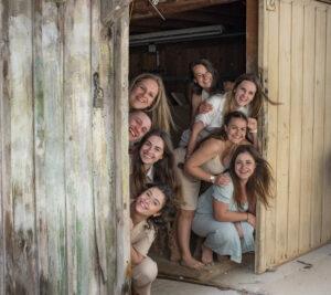 séance EVJF, huit personnes dans une vielle grange sortent la tête de chaque cote de la porte