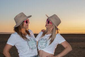 séance photo EVJF deux jeune filles sur la plage face à face avec des chapeaux
