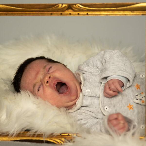 photographe naissance bébé le bouscat bebe qui baille dans un cadre doré -photographe de naissance- krystyne ramon