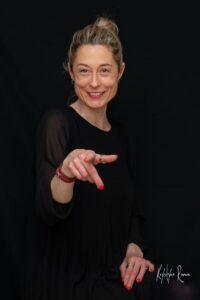 portrait d'une femme qui sourit et la main en avant photographe de portrait- krystyne ramon - home studio photos