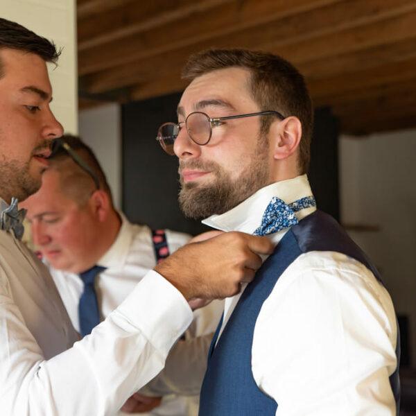 Futur marié se fait aider à mettre son noeud papillon par un de ses deux témoins- photographe de mariage- krystyne ramon