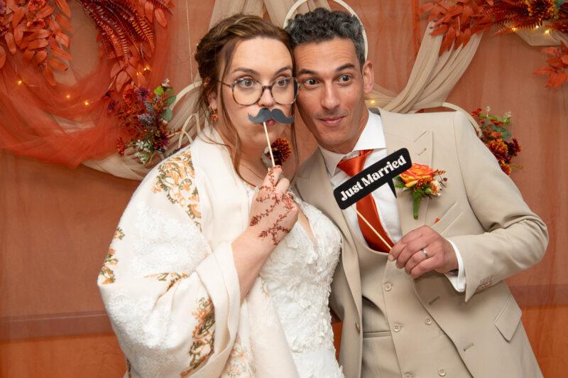 couple de mariés devant un photobooth pour se prendre en photo