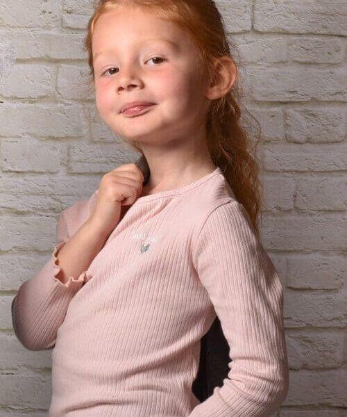 portrait d'une petite fille rousse de profil tenant une veste sur une épaule krystyne ramon - home studio photos
