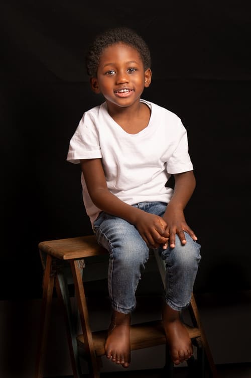 portrait enfant garçon de couleur assis sur un escabeau en bois - krystyne ramon - home studio photos
