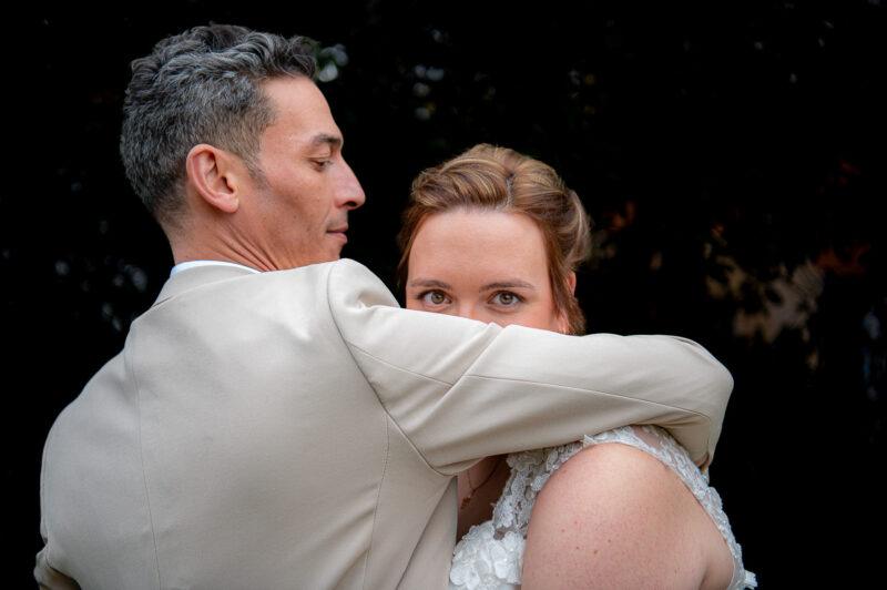 Couple de mariés enlacés dans un jardin