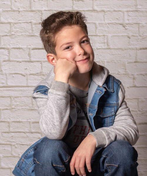 portrait du jeune garçon assis sur un escabeau le bras accoudé sur un genou krystyne ramon - home studio photos