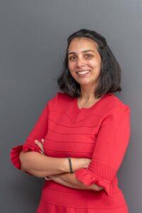 Femme d'affaire debout en robe rouge les bras croisés séance photo portrait